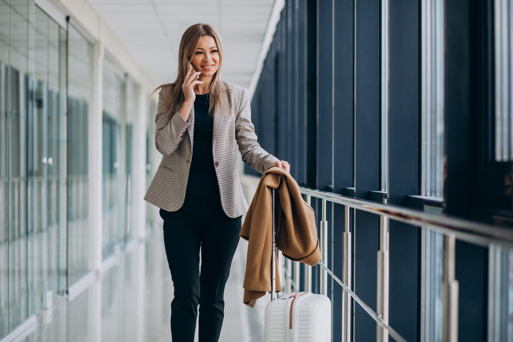 Mulher de negócios sorridente no aeroporto em viagem corporativa.